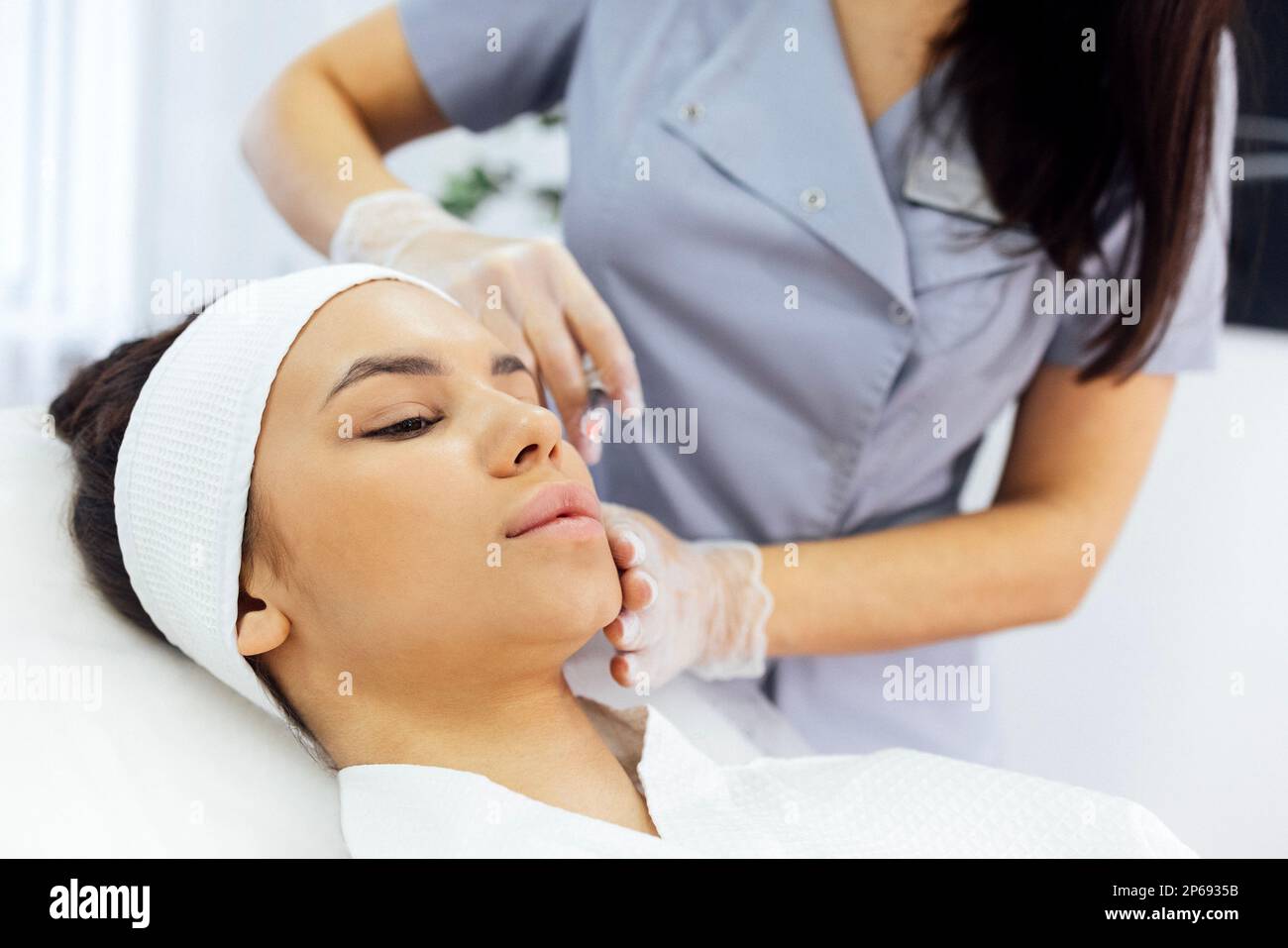 Beauty injections. Female cosmetologist in transparent gloves makes an
