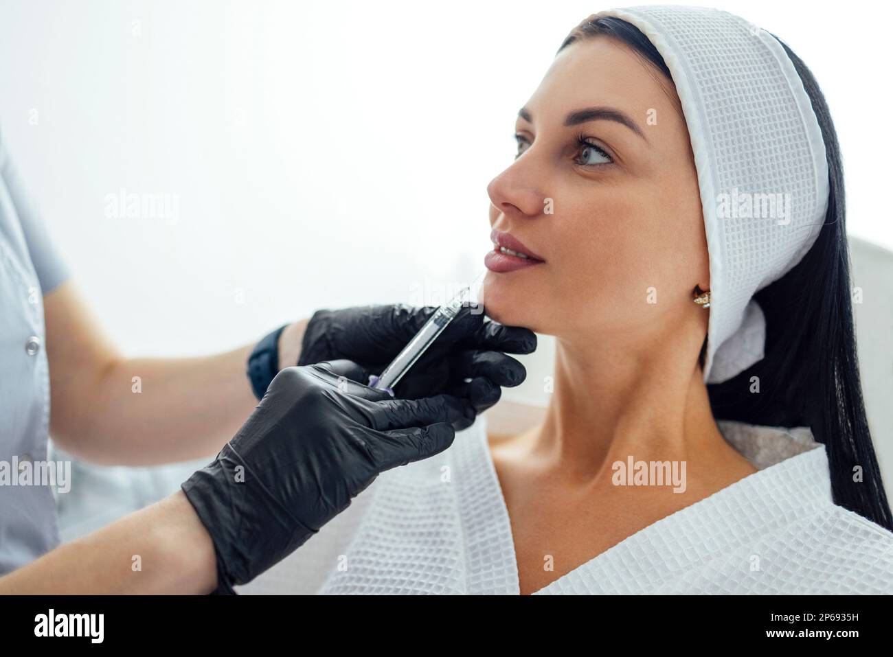Beauty injections. Female cosmetologist in transparent gloves makes an