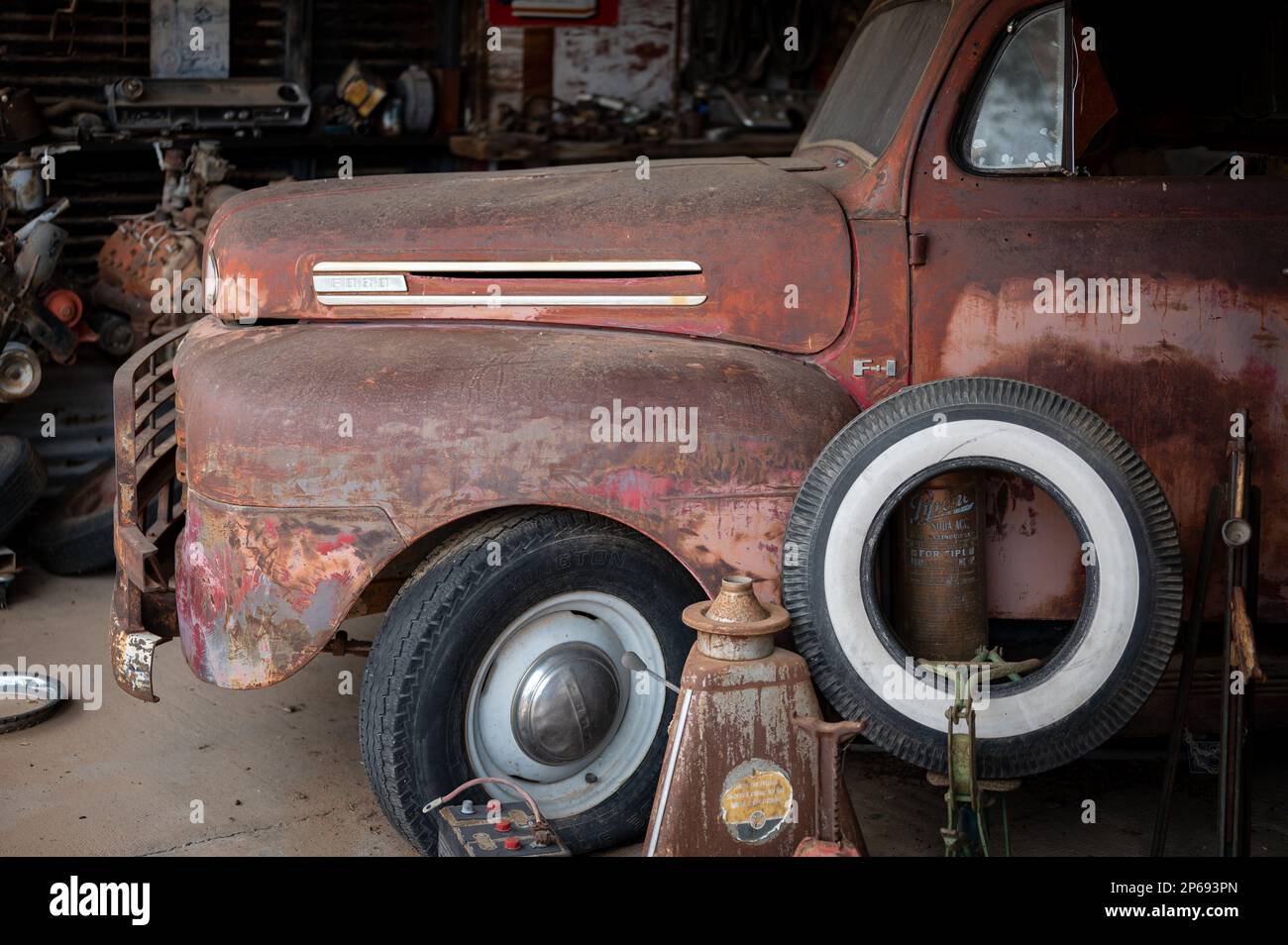 Old abandoned car mechanic shop on the desert road. Inside is an old Ford F-1 pickup. Stock Photo