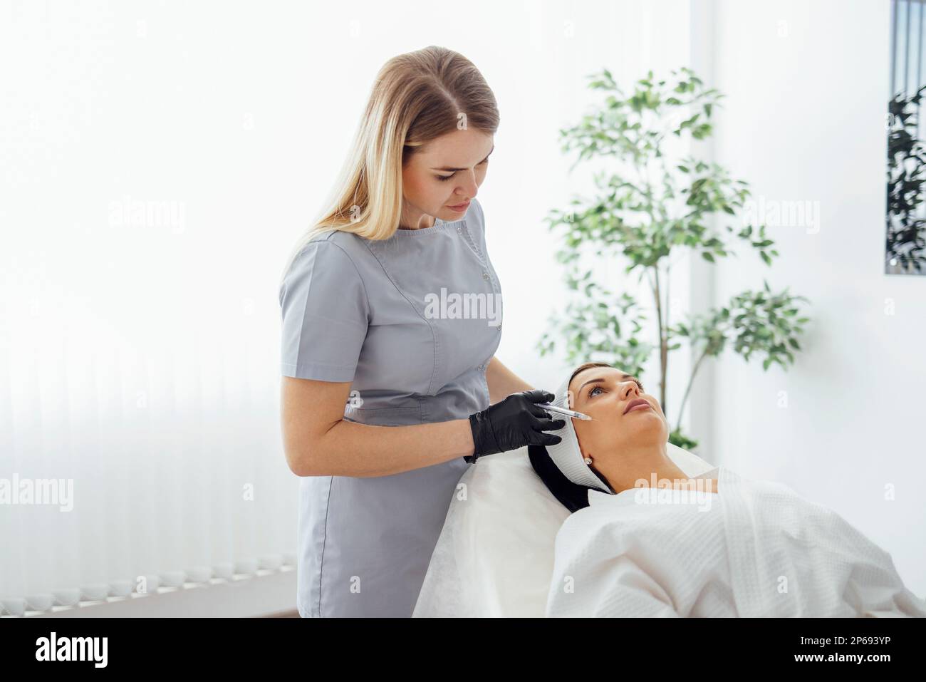 Beauty injections. Female cosmetologist in transparent gloves makes an ...