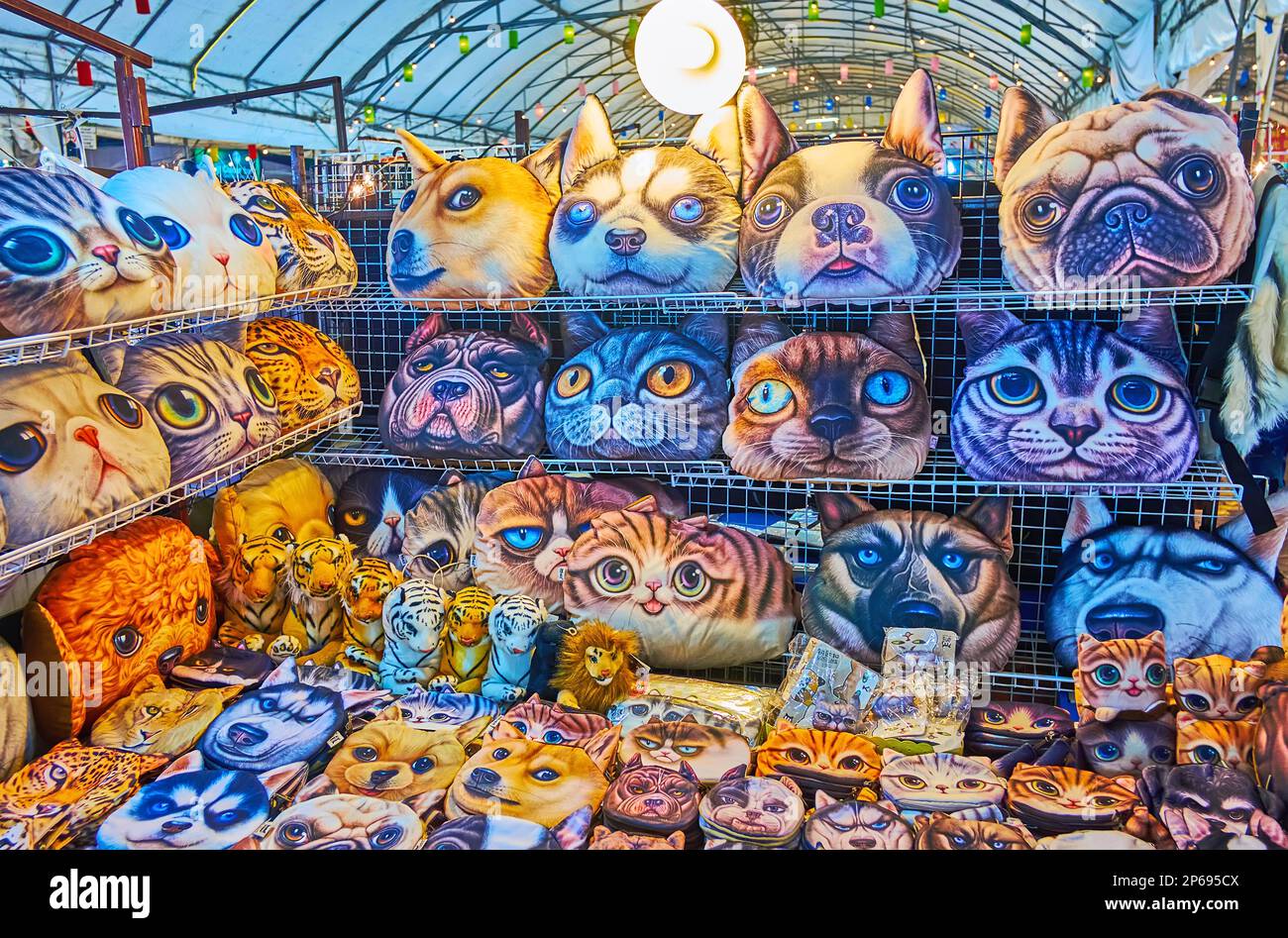 The funny dogs and cats heads pillows and small bags in a stall of Anusarn Night Market, Chiang Mai, Thailand Stock Photo