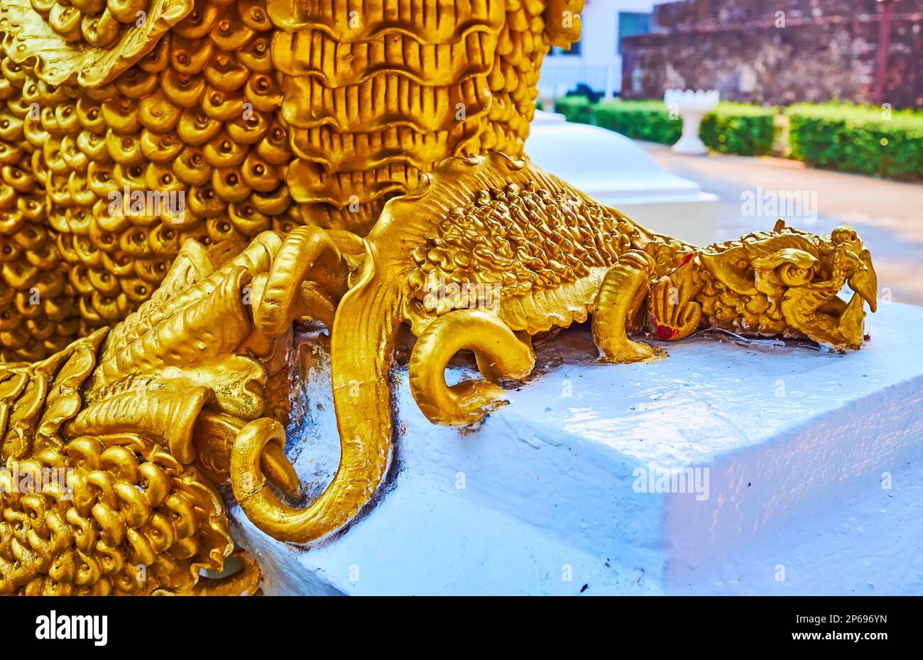 The tiny dragon-like sculpture of Mom mythic creature at the feet of bigger one, Wat Umong Mahathera Chan, Chiang Mai, Thailand Stock Photo