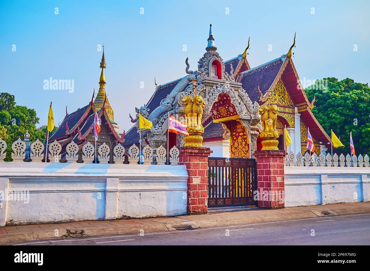 The gate of Wat Buppharam temple is decorated with gilt lion pillars, Chiang Mai, Thailand Stock Photo