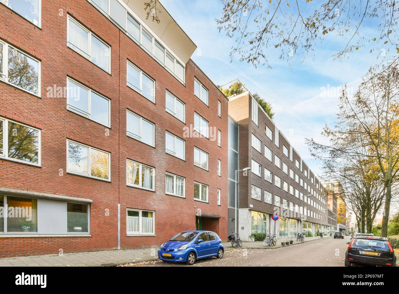 a city street with cars parked on the side and buildings in the back ...