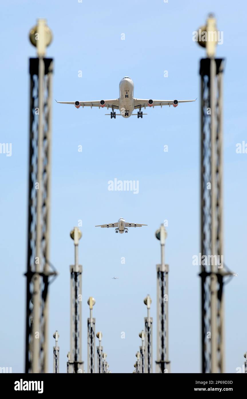 Planes are flying over landing lights in an airport Stock Photo Alamy