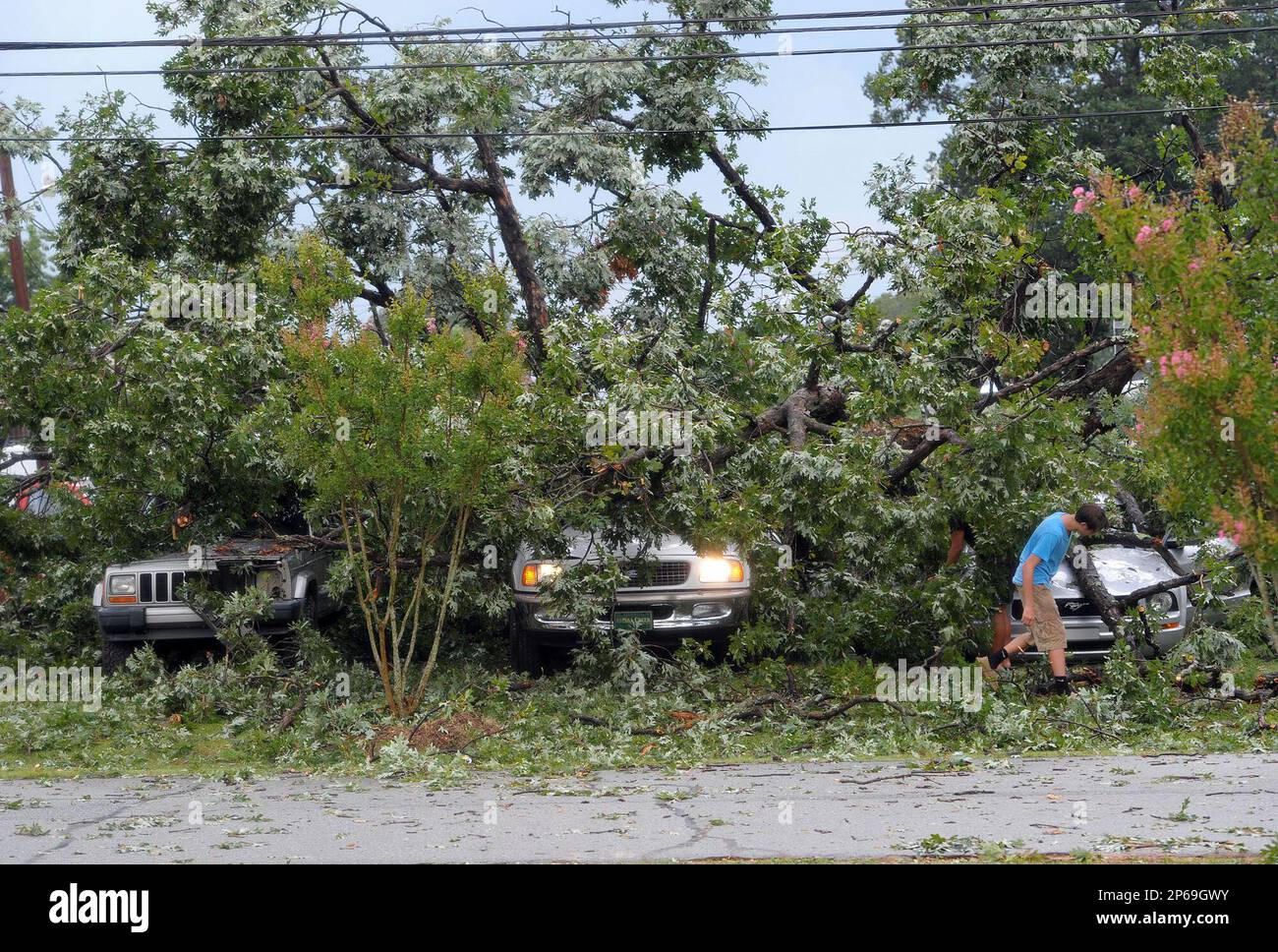 Roman Stanley, 16, surveys the damage done to his Ford Mustang after a