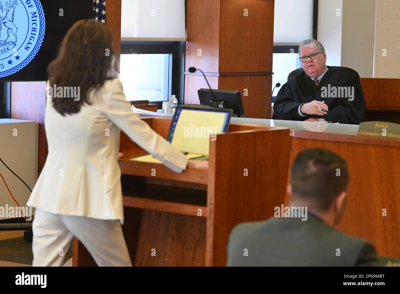 Michigan Court of Appeals Judge Michael Riordan, speaks with attorney
