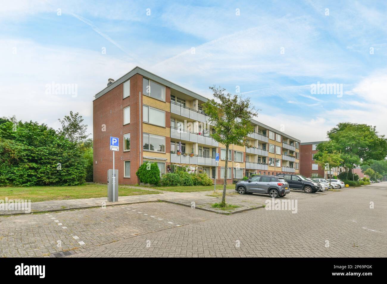 an apartment complex with cars parked on the side of the street in ...
