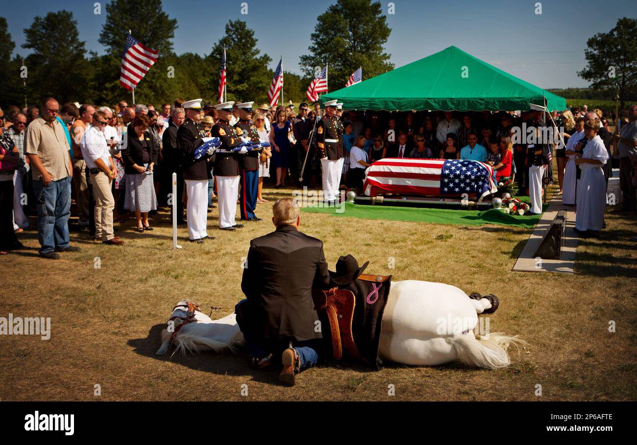 Taylor Rudd of Lubbock, Texas, kneels to pray with his horse, White ...