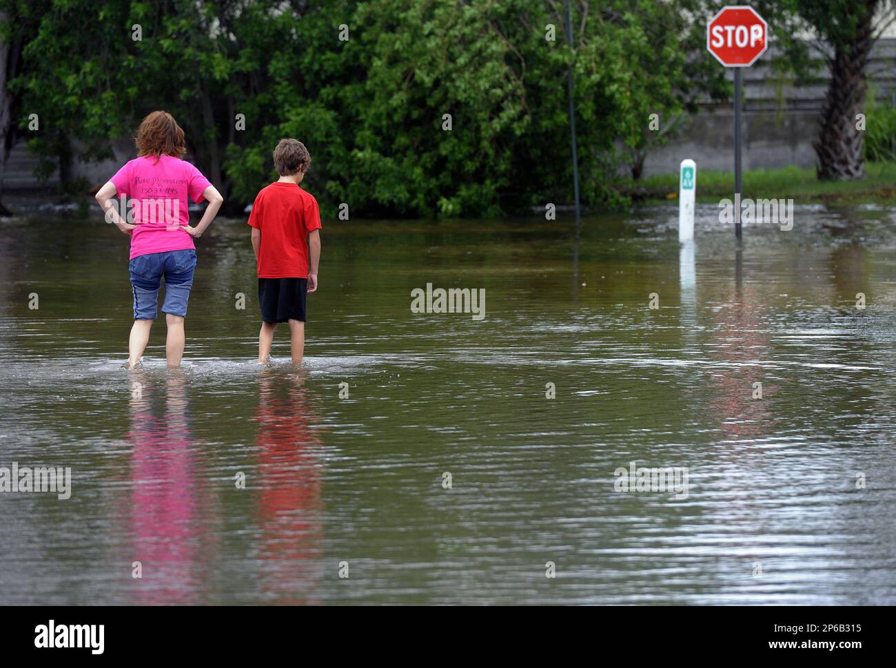 People walk through floodwaters left by Tropical Storm Debby on 