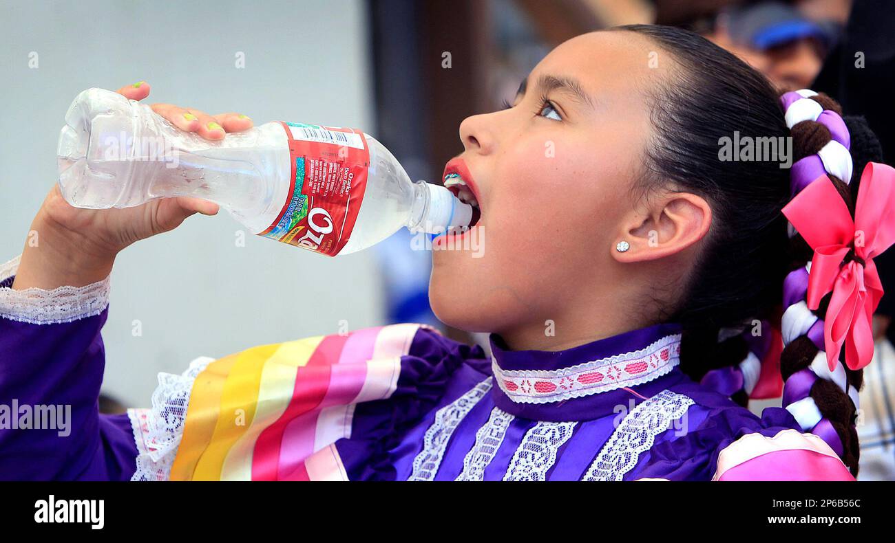 Catherine Manrique, 11, takes a drink before going on stage with the Los Bailadores of Kansas