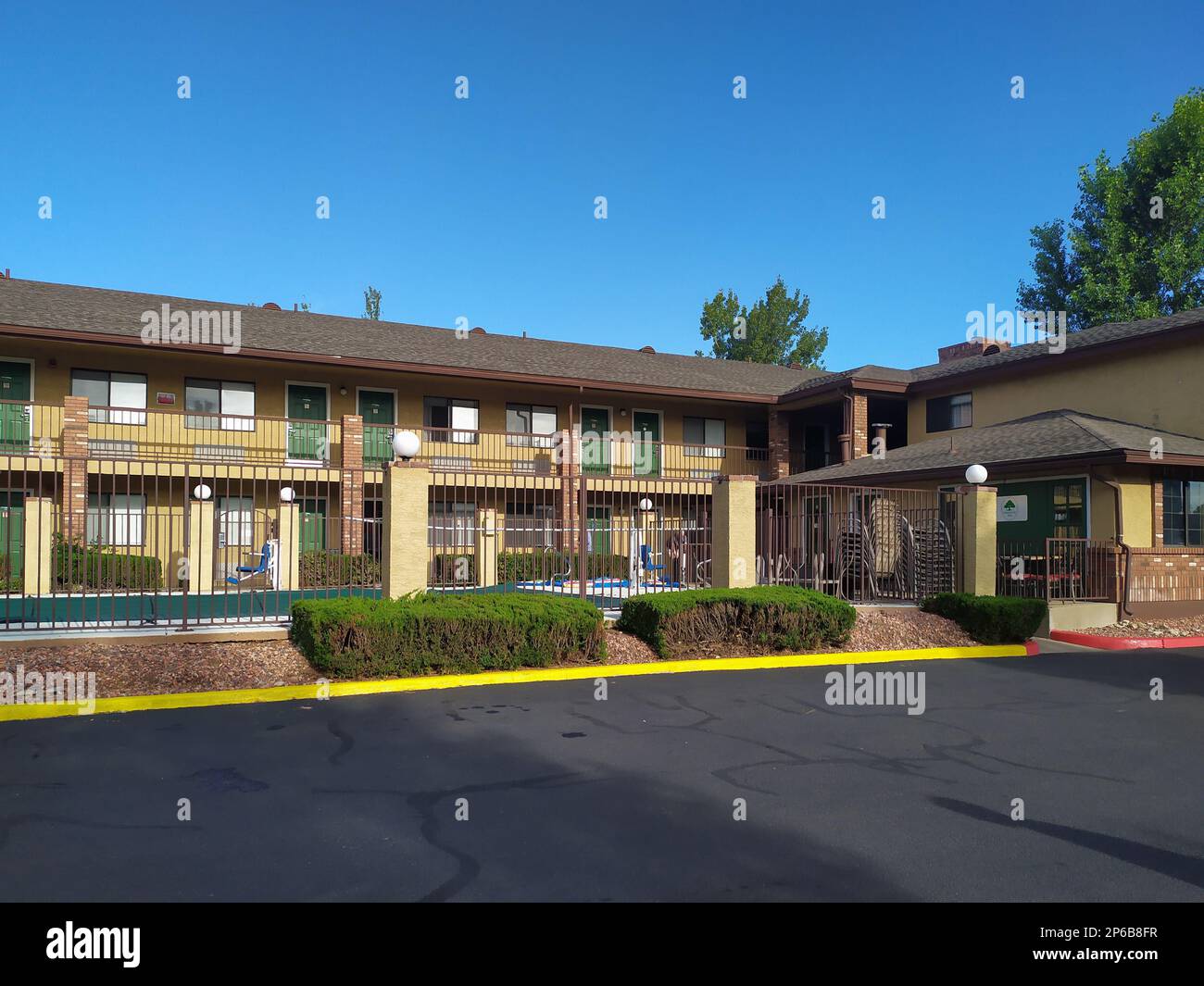 A motel building with many rooms on the second floor and one room off