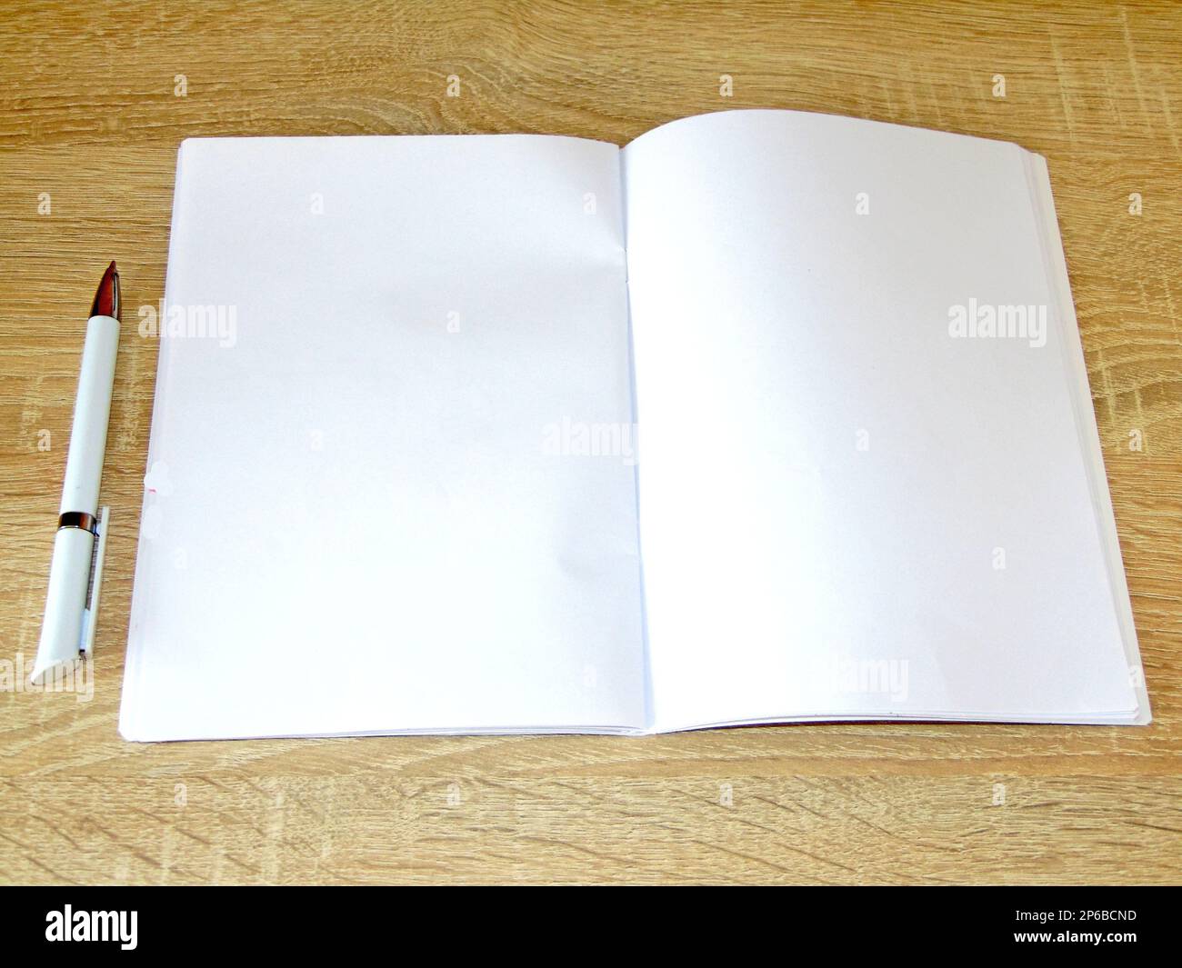 notebook with white pages and a pen on a wooden background Stock Photo