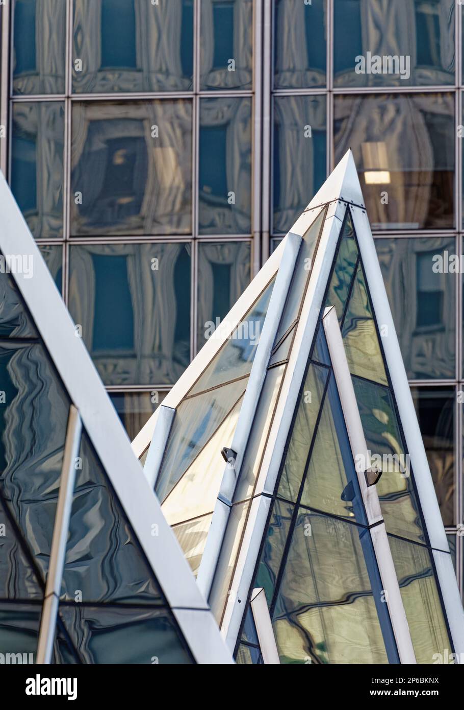 Chrysler Trylons, designed by postmodern master Philip Johnson, is notable for its steel-framed glass pyramids, shown here against 666 Third Avenue. Stock Photo