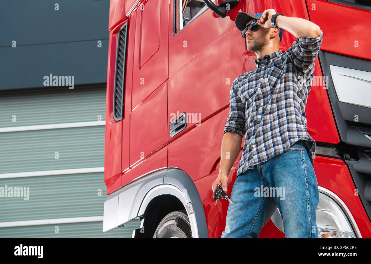 https://c8.alamy.com/comp/2P6C2RE/middle-age-caucasian-trucker-wearing-sunglasses-and-a-hat-in-front-of-his-brand-new-semi-truck-tractor-transportation-industry-theme-2P6C2RE.jpg