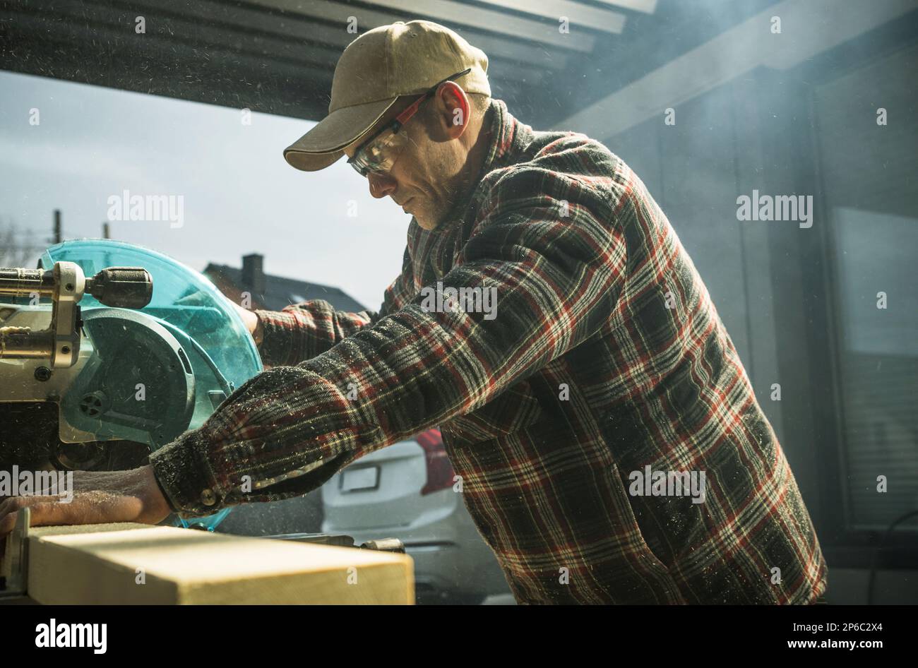 Woodworker Contractor Cutting Wood Beams To Size. Small Construction Project Theme. Stock Photo