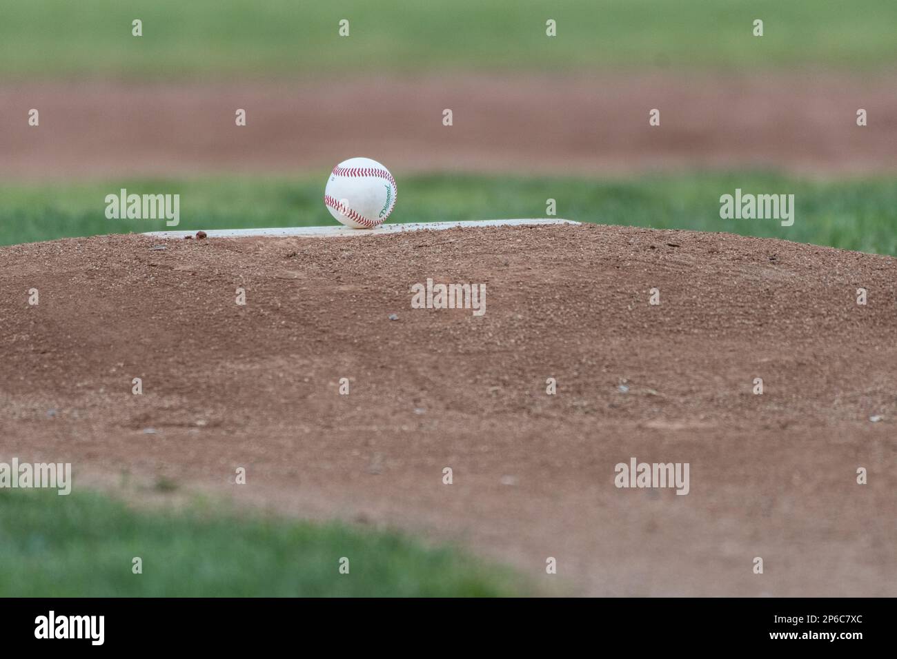 Pitching rubber has new clean ball on baseball infield mound for game