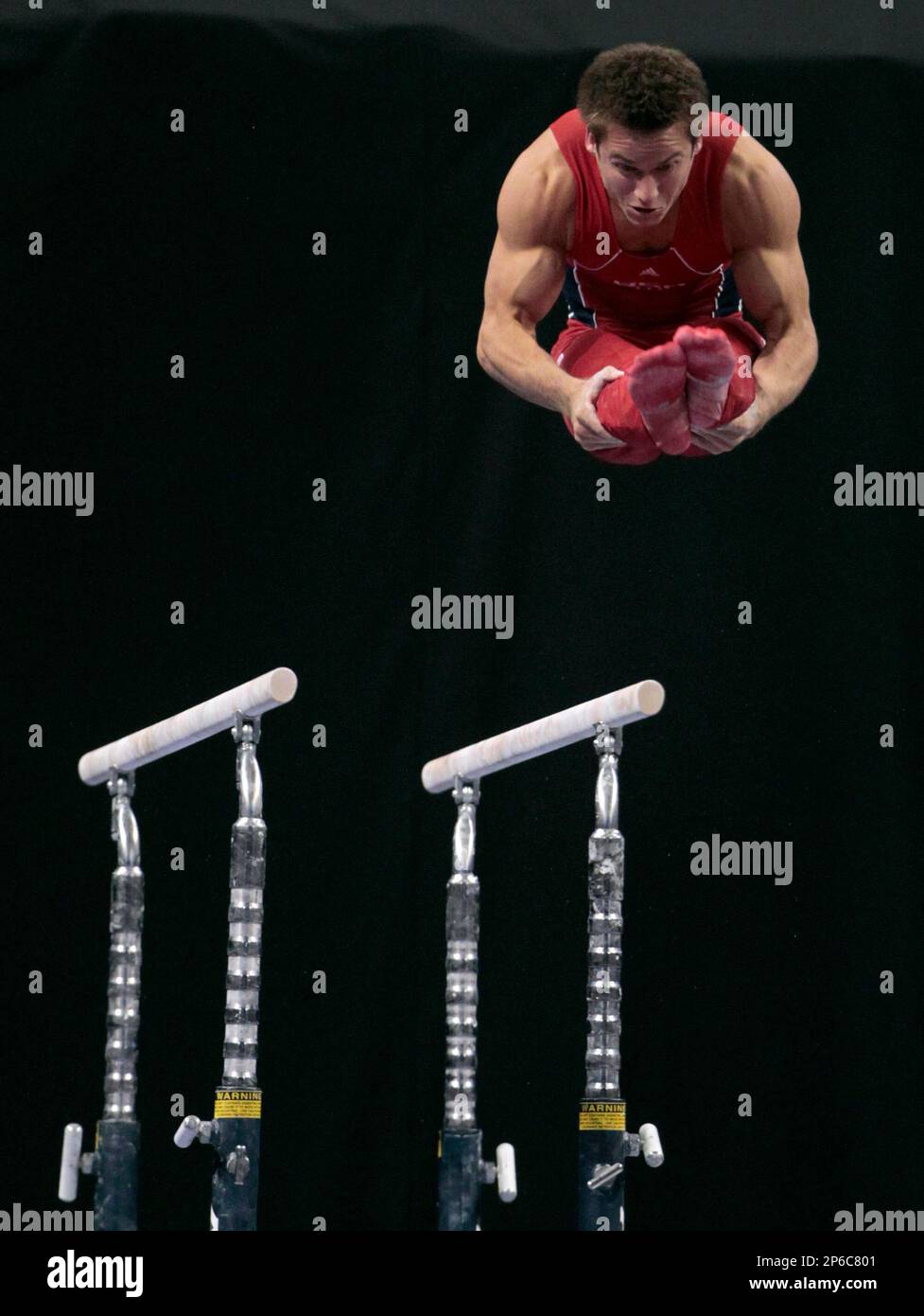 Sam Mikulak dismounts the parallel bars during the men's senior