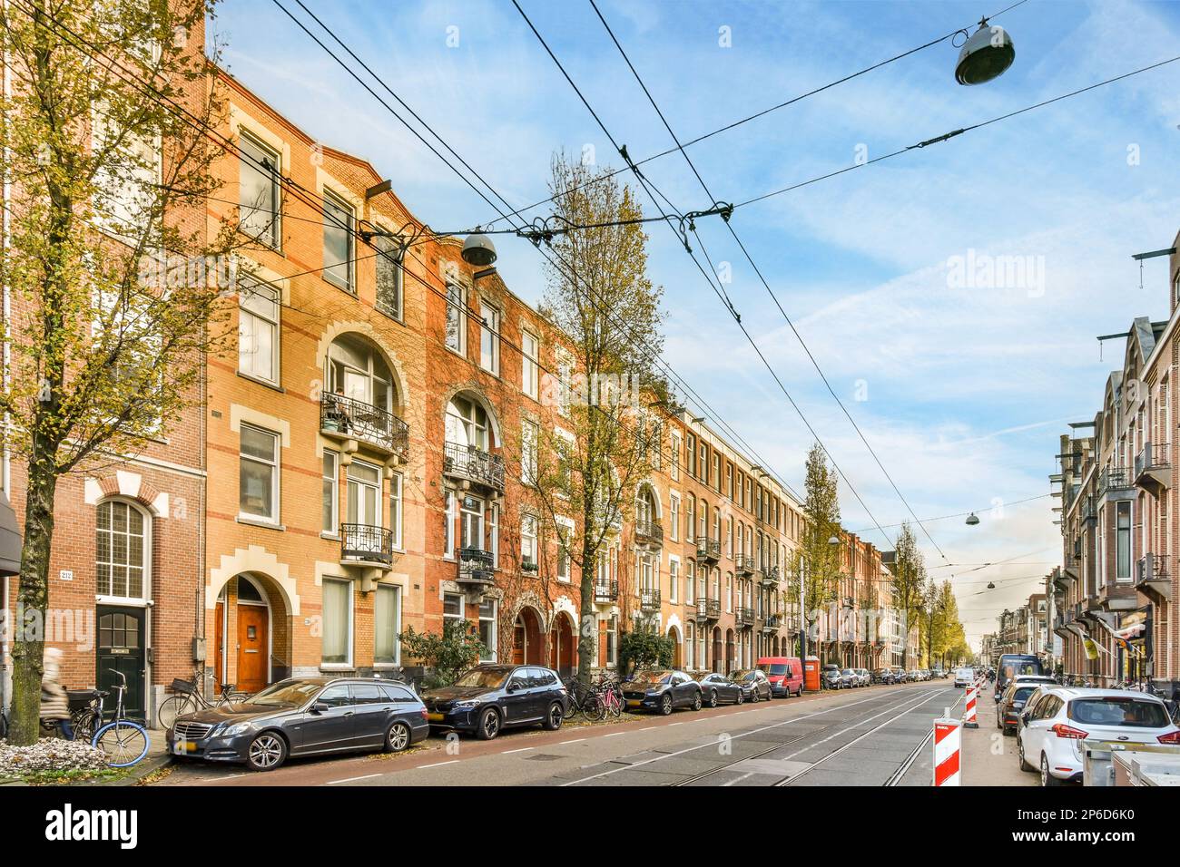 a city street with cars parked on both sides and buildings in the same ...
