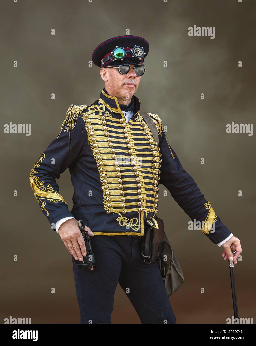 A male steampunk wearing a pseudo military officer's uniform and holding a cane. Stock Photo