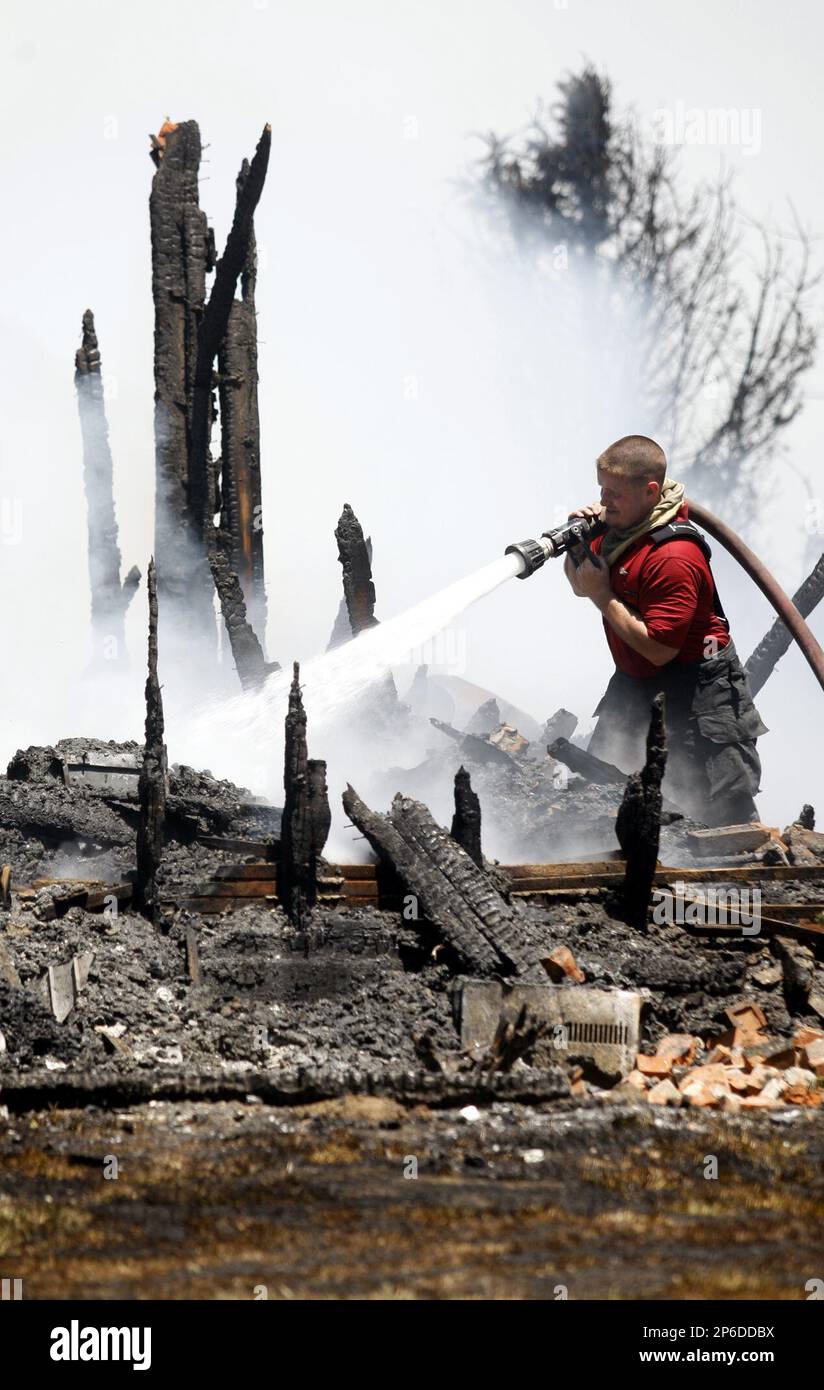 Winchester volunteer firefighter Bryan Taylor directs the fire hose at