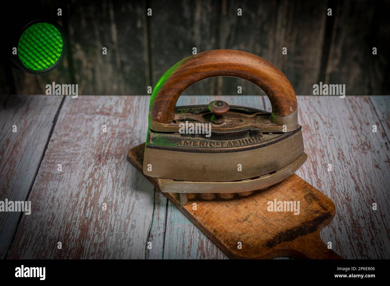 Old metal iron on old wooden blue table with dirty chopping board Stock Photo