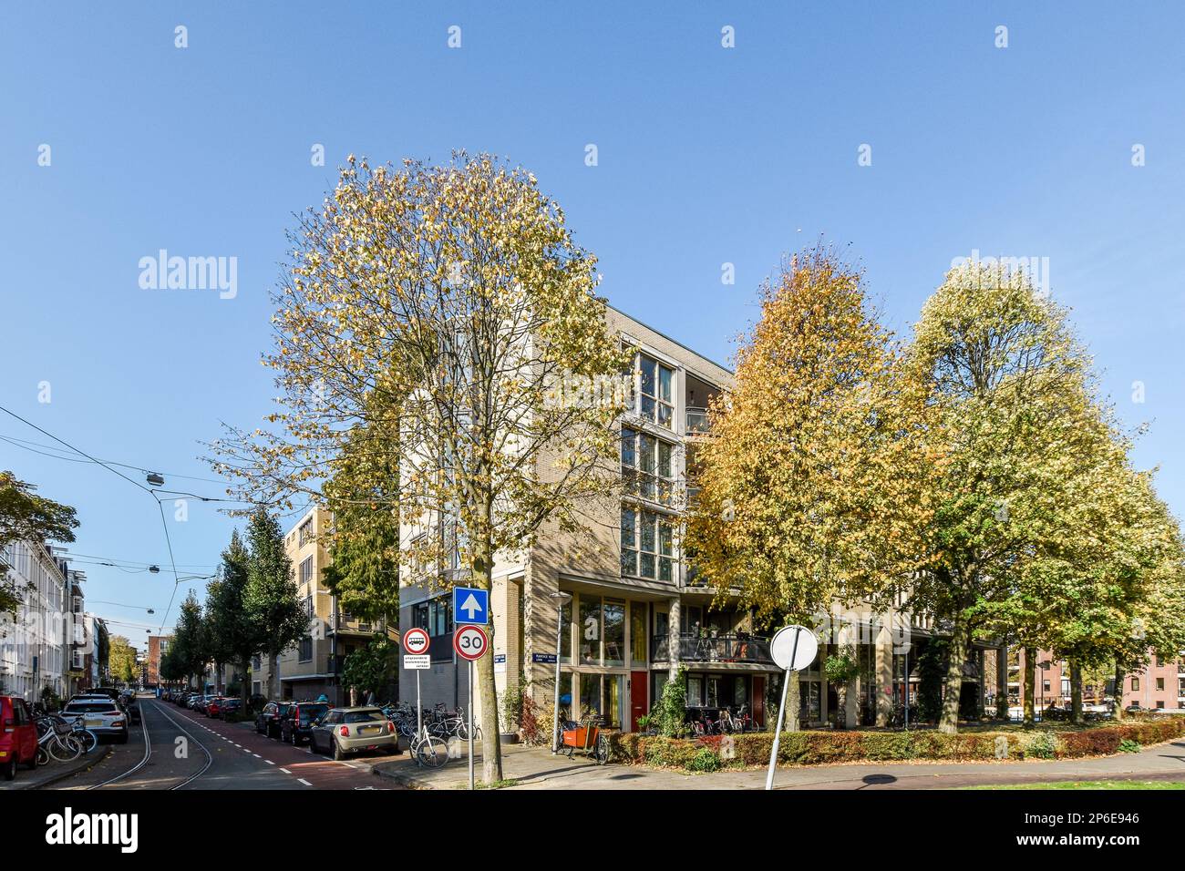 a city street with cars parked on the side of the road and buildings in ...