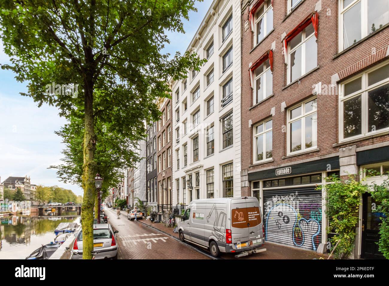 a city street with cars parked on the side and buildings in the back ...