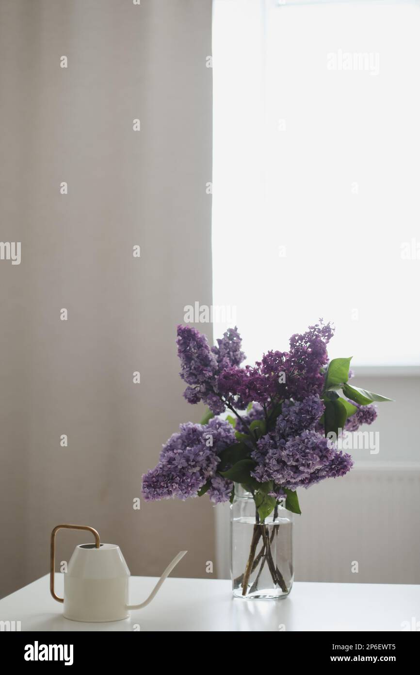 Home interior decor, bouquet of lilacs in a vase on table. Spring still ...
