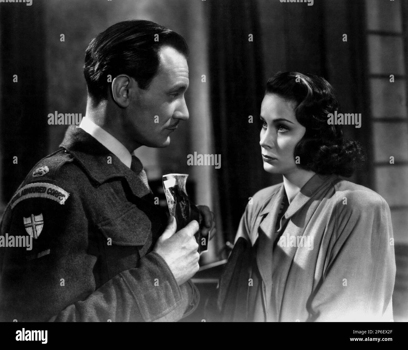 1949 : The  movie actor TREVOR HOWARD with italian actress ALIDA VALLI   in a pubblicitary shot  for THE THIRD MAN ( Il terzo uomo ) by Carol Reed , from a novel by Graham Greene - FILM NOIR  - CINEMA - ATTORE CINEMATOGRAFICO  - FILM - TRILLER - SUSPANCE  - duo - coppia - military uniform - uniforme divisa militare  ----  Archivio GBB      Archivio Stock Photo