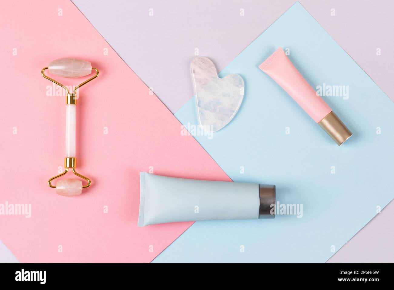 Pink jade roller and gua sha for face massage with cream or gel for the