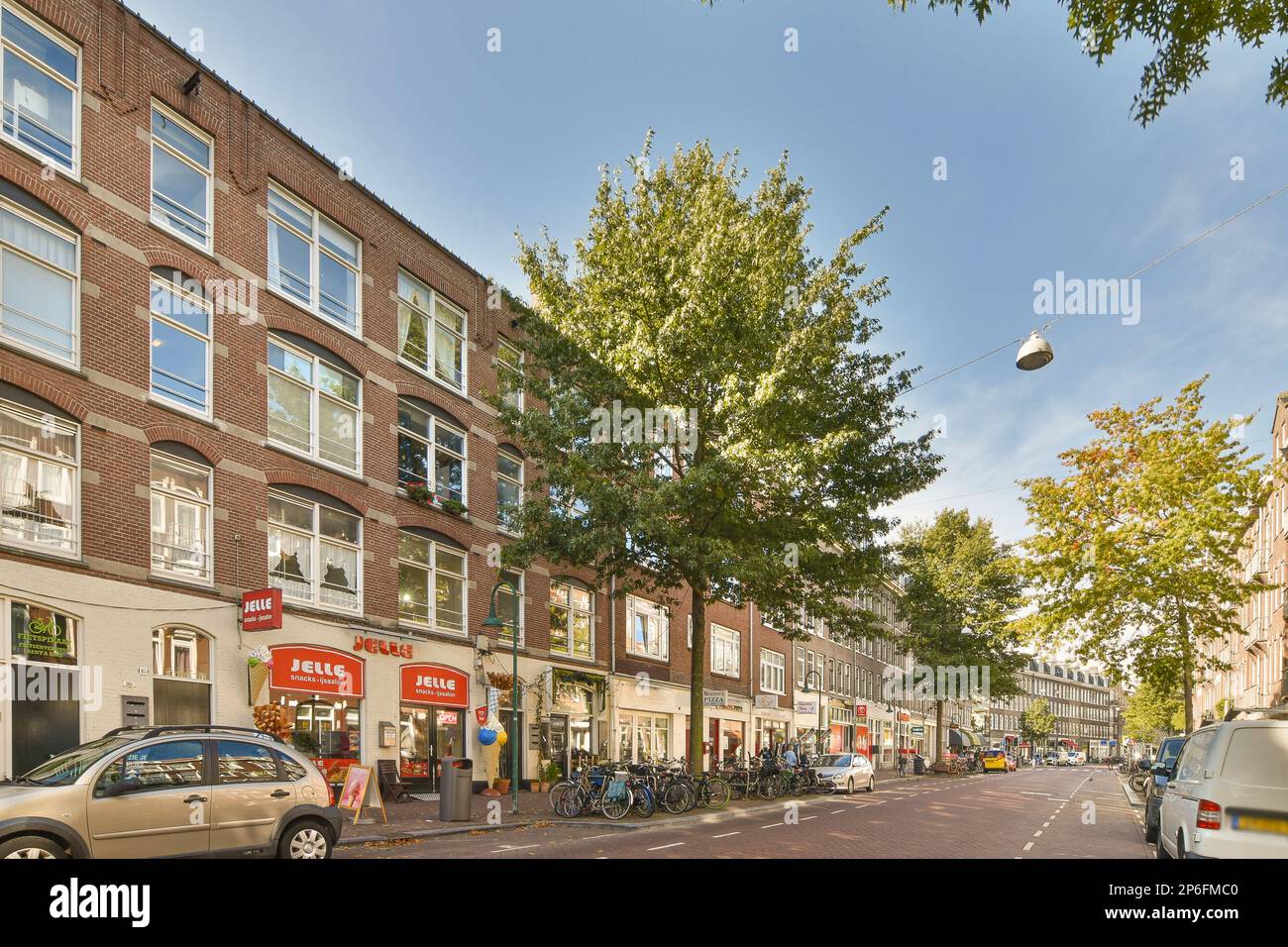 a city street with cars parked on the side of the road and buildings in ...