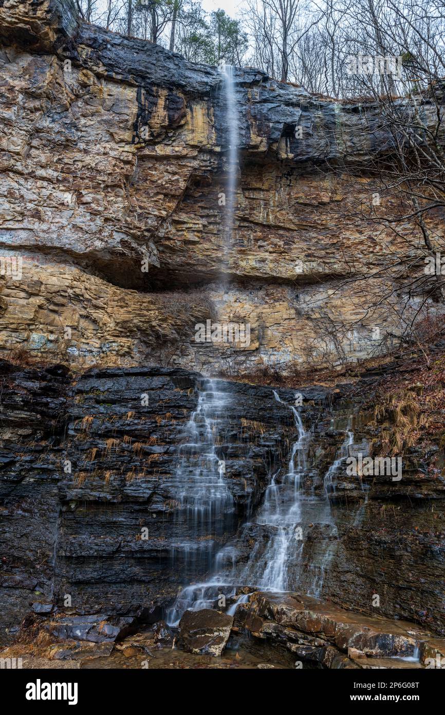 A majestic waterfall cascading down a sheer rock face into a tranquil ...