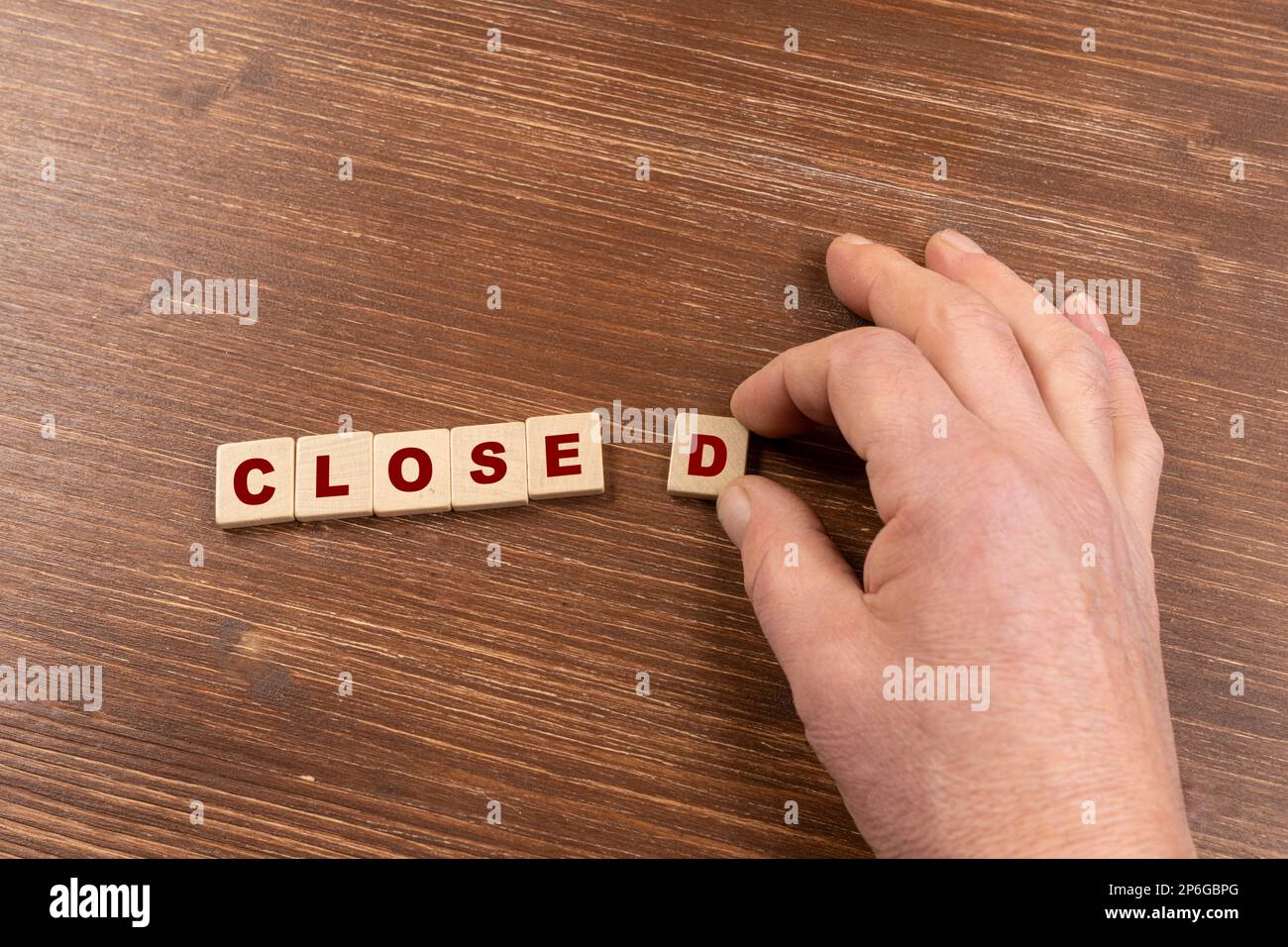 the word Closed formed with small wooden tablets on a colored surface