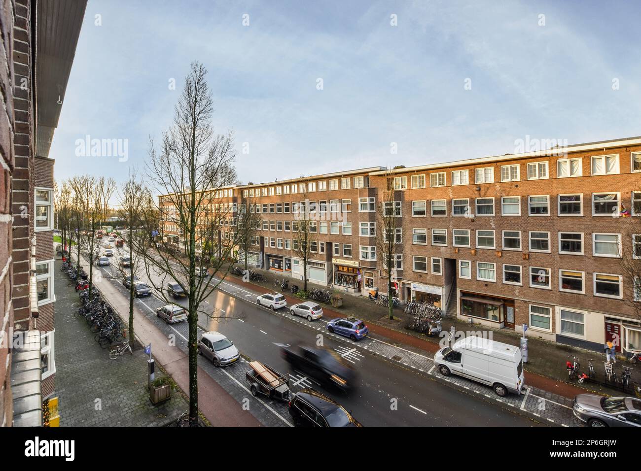 a city street with cars parked on the side and buildings in the ...