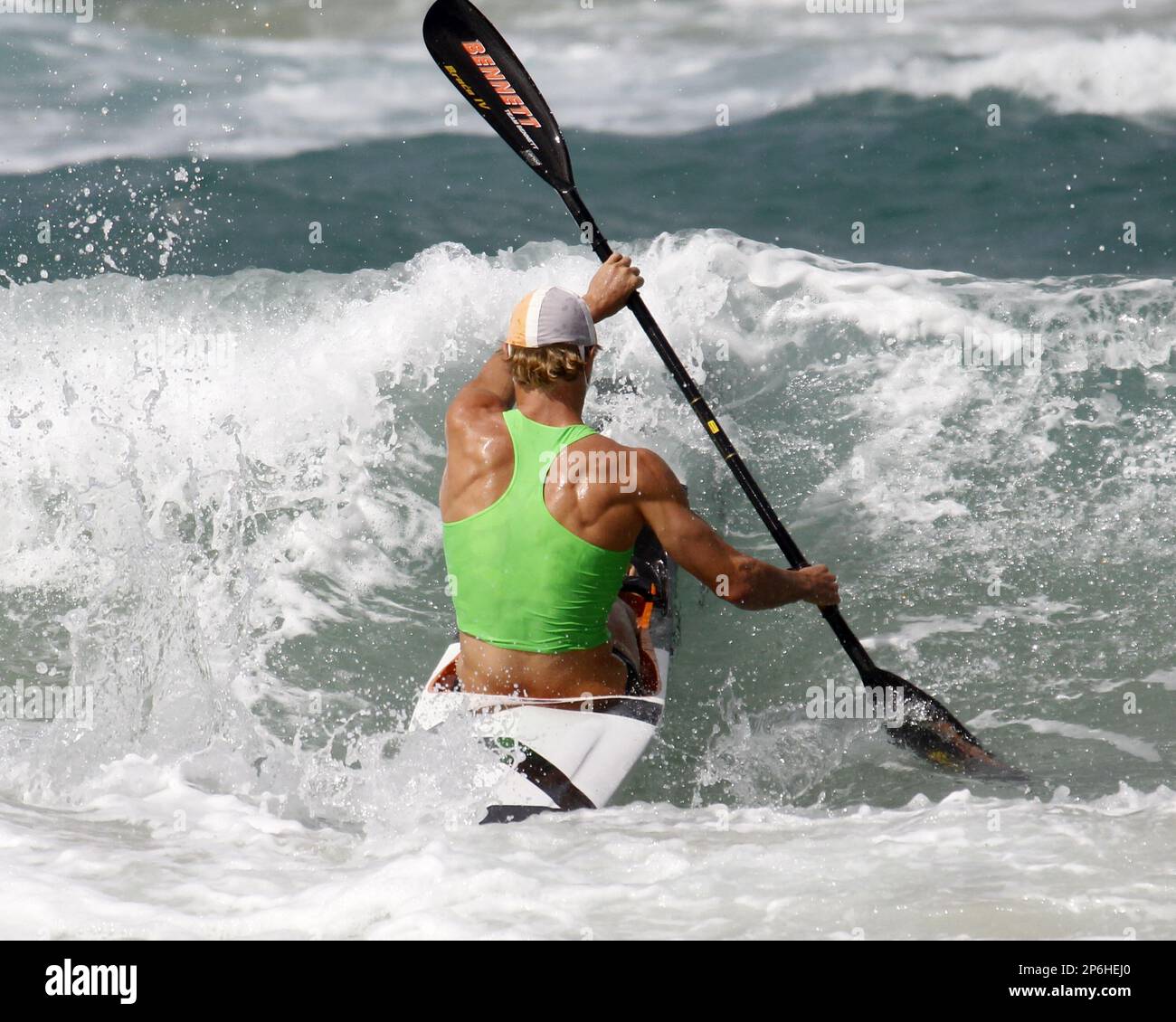 Hayden White, of Australia, paddles out into the surf, in the Men's Ski