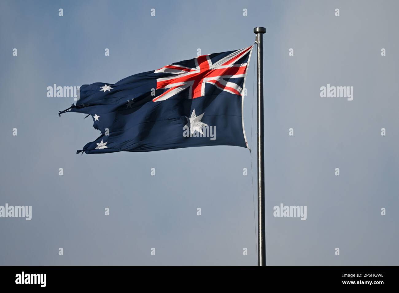 A tattered Australian flag is seen on top of the Australian Parliament ...