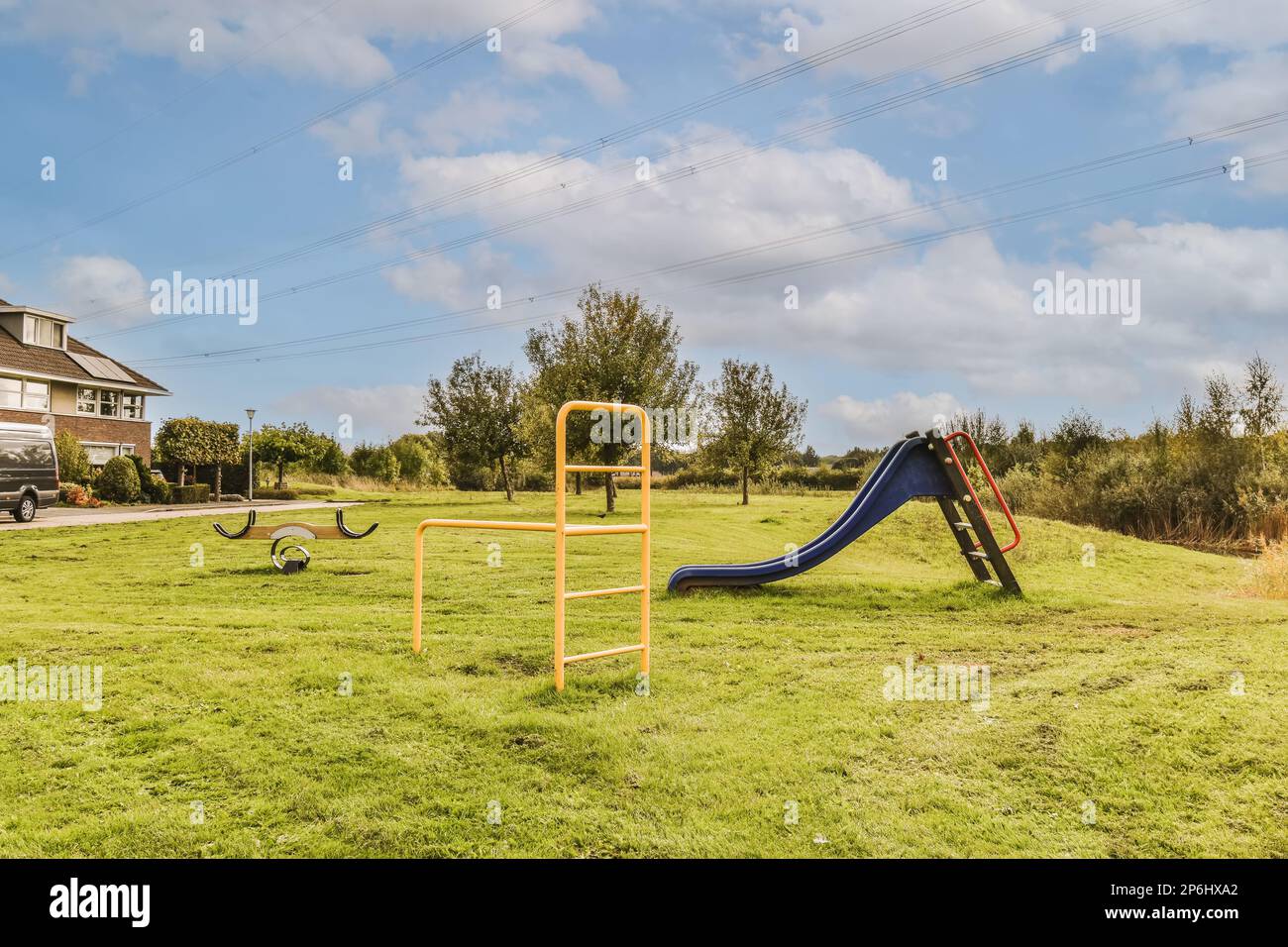 an empty playground in the middle of a residential area with blue sky ...