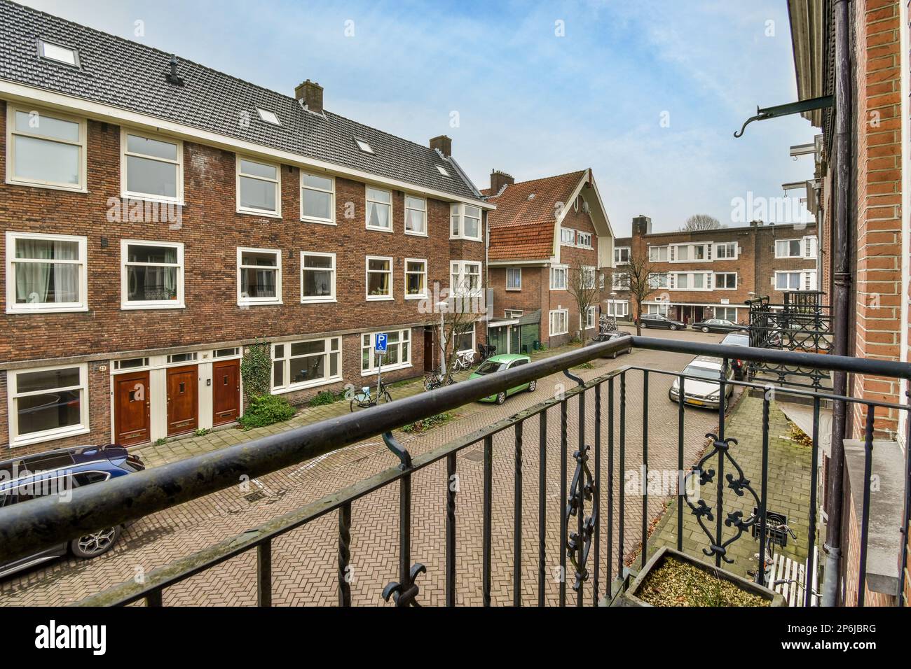 an outside area with cars parked on the street and houses in the ...