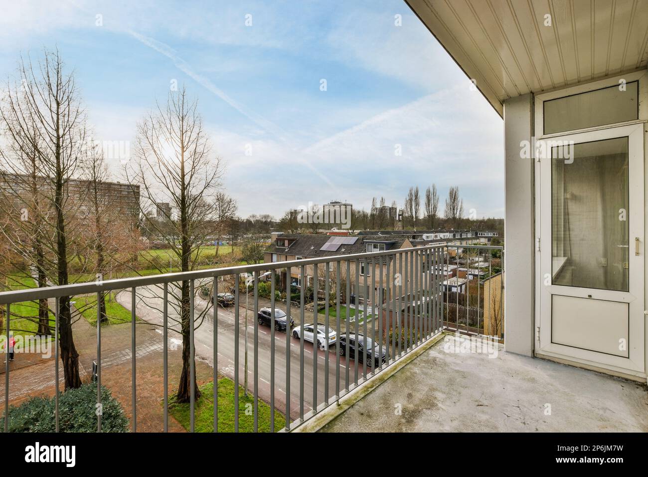 a balcony with cars parked on the street and buildings in the distance ...