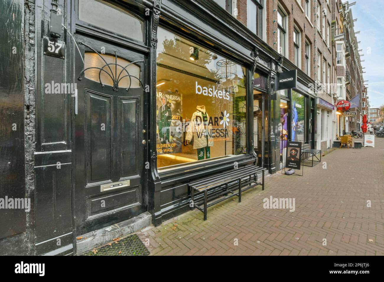 Amsterdam, Netherlands - 10 April, 2021: a store on the side of a city street with people walking by and looking at their reflection in the window Stock Photo