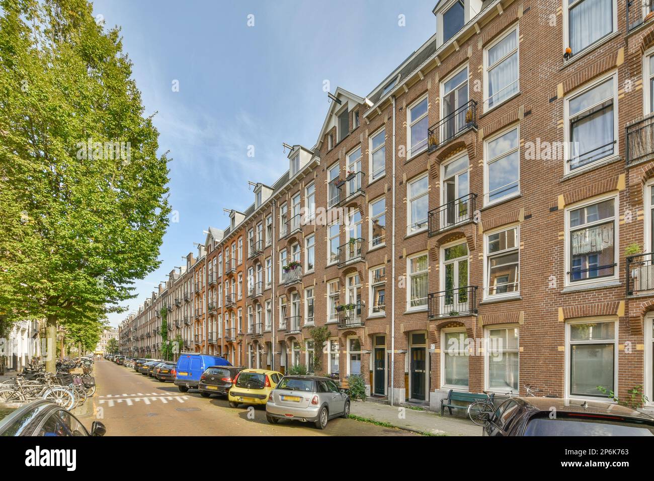 a city street with cars parked on the side and buildings in the back ...