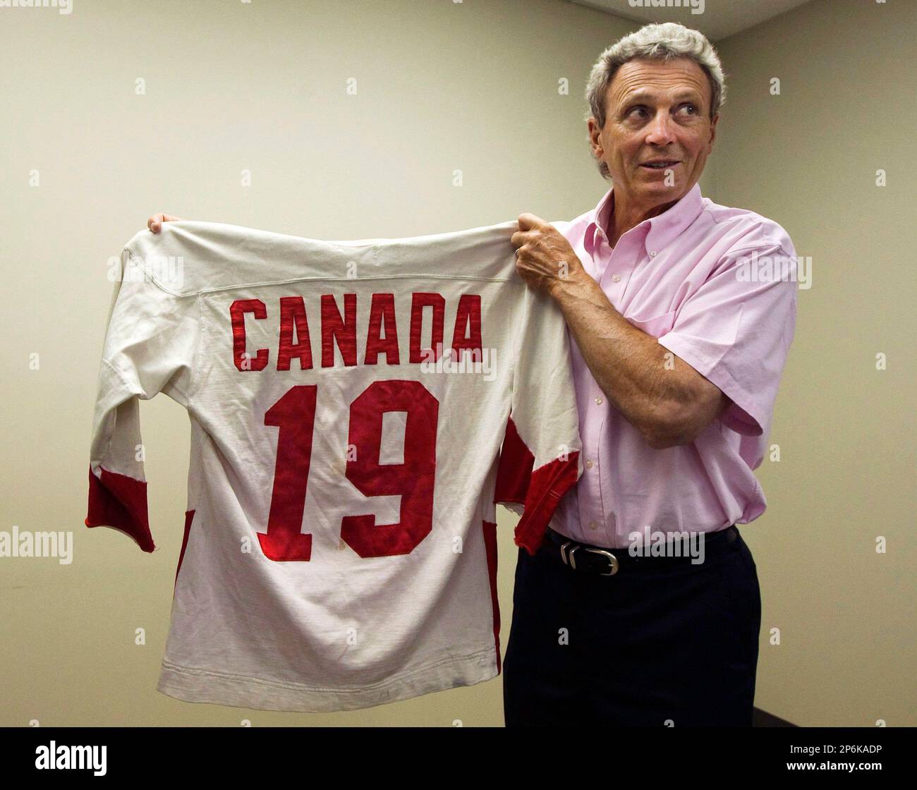 In this photo taken June 7,2012, Canadian hockey legend Paul Henderson  holds his original 1972 Team Canada jersey in his office in Mississauga,  Ontario, Once again, Henderson is credited with making hockey