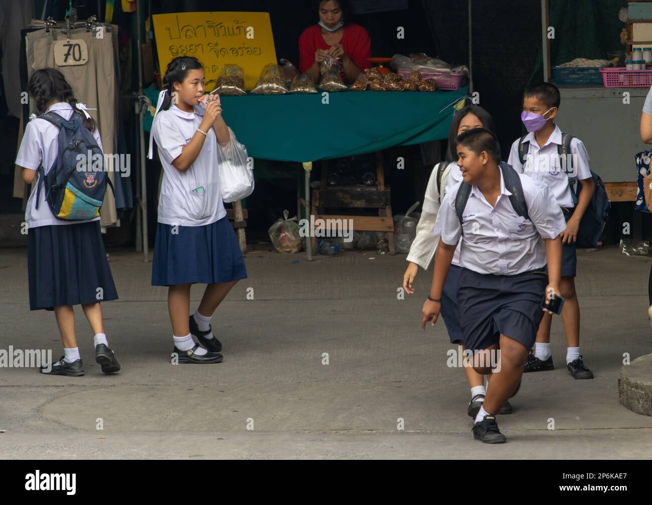 SAMUT PRAKAN, THAILAND, FEB 17 2023, Children in school uniforms play on the street on their way home from school Stock Photo