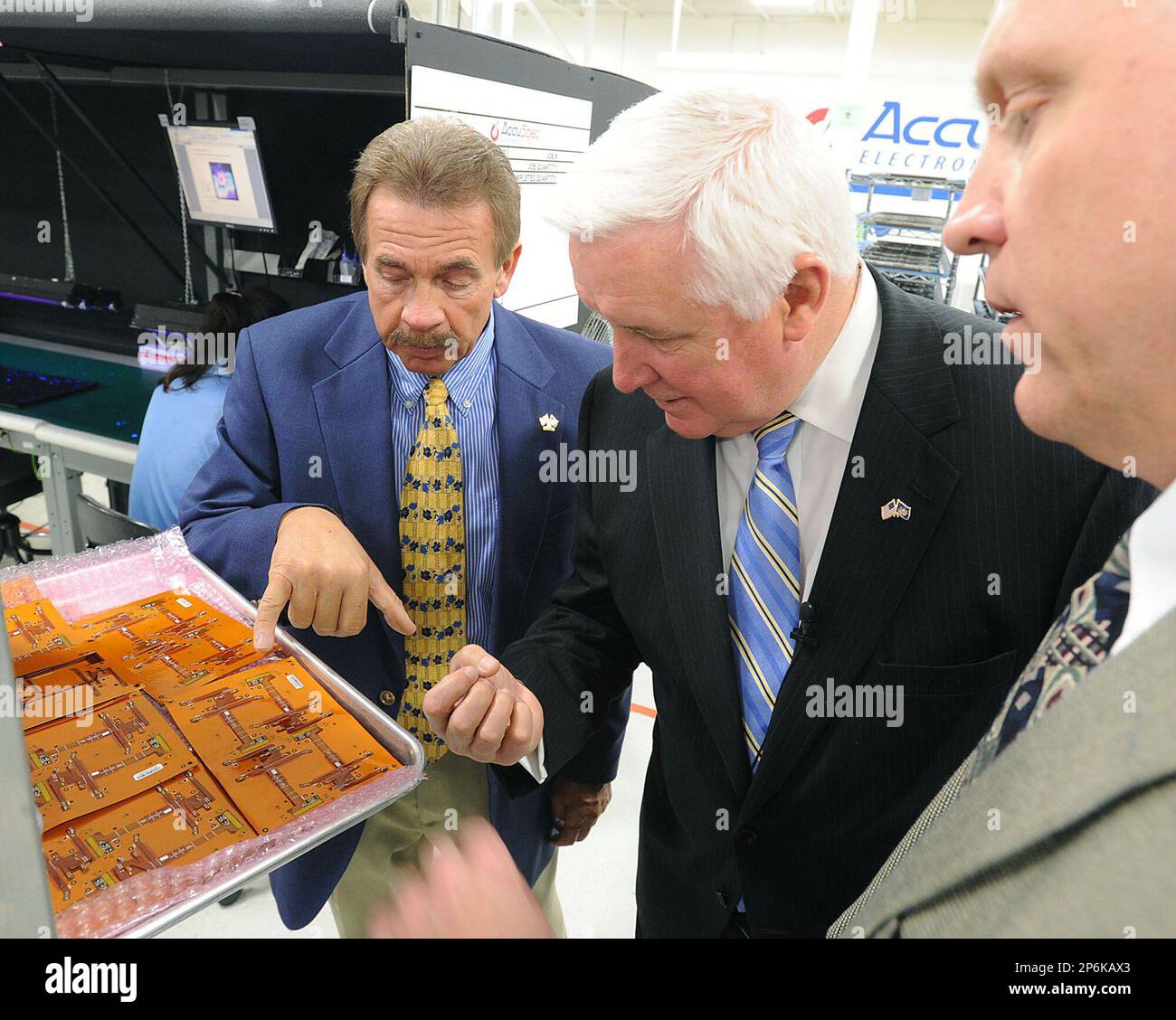 AccuSpec Electronics vice president of sales Bob left, shows electronic circuits to