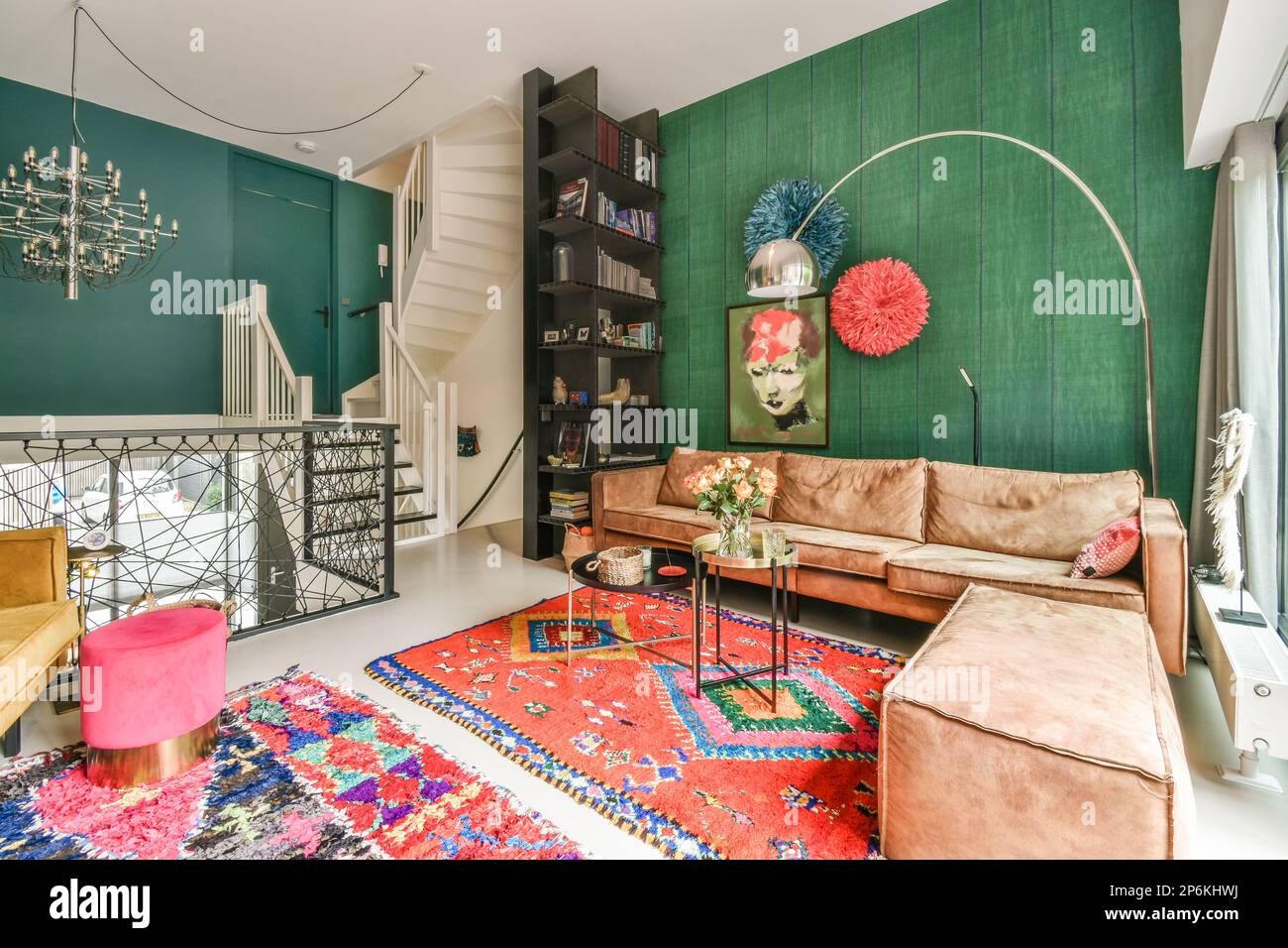a living room with green walls and colorful rugs on the floor in front of couches, coffee tables and chairs Stock Photo
