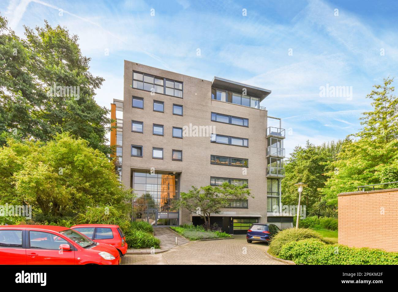 an apartment complex with cars parked in the driveway and trees on ...