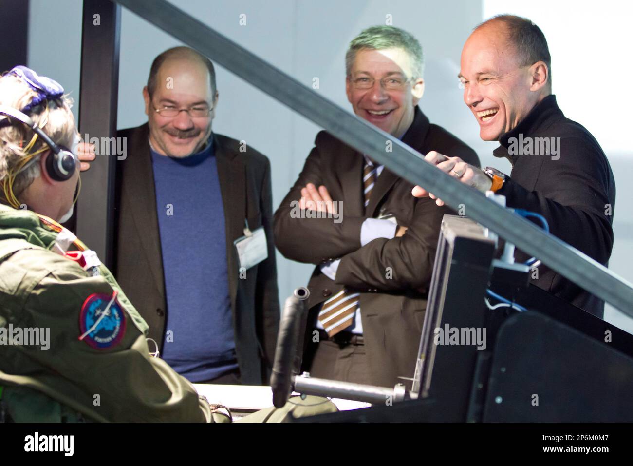 Solar Impulse pilot Andre Borschberg, left, sits in a flight simulator and talks with Betrand Piccard, right, and Martin Buetikofer, direktor of the Swiss Transport Museum Lucerne, second right, in Duebendorf, Switzerland, Tuesday Feb. 21, 2012. Man second left is not identified. Solar Impulse will simulate a 72 hours flight from Feb. 21 to Feb.24 , 2012 as preparation of the flight project around the world with the solar airplane by Swiss Bertrand Picard and Andre Borschberg . (AP Photo/Keystone/Alessandro Della Bella) Stock Photo