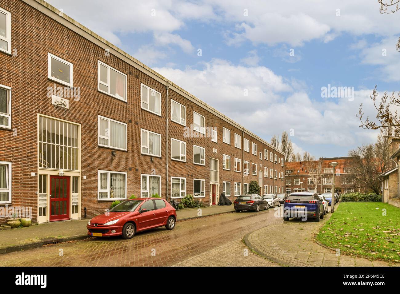 a street with cars parked on the side and buildings in the back ground ...