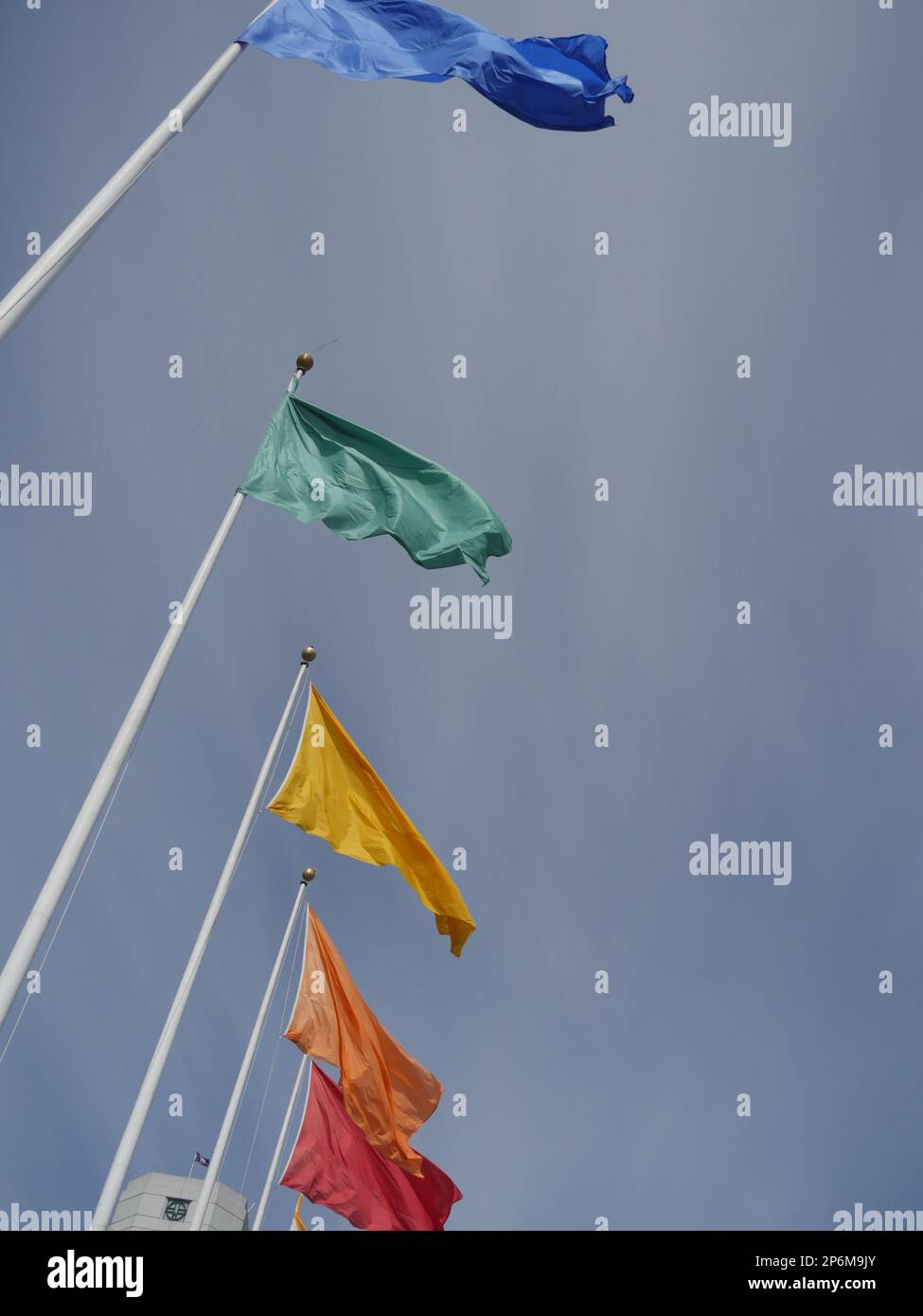Flags of different colors on flagpoles Stock Photo